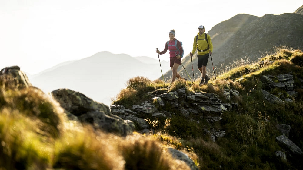 Wanderer auf einem Pfad in Saalbach Hinterglemm, umgeben von Bergen.